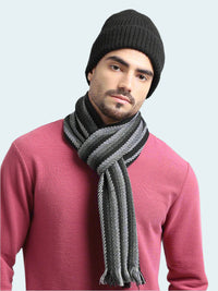 Man wearing a black knit beanie and gray scarf against a light gray background