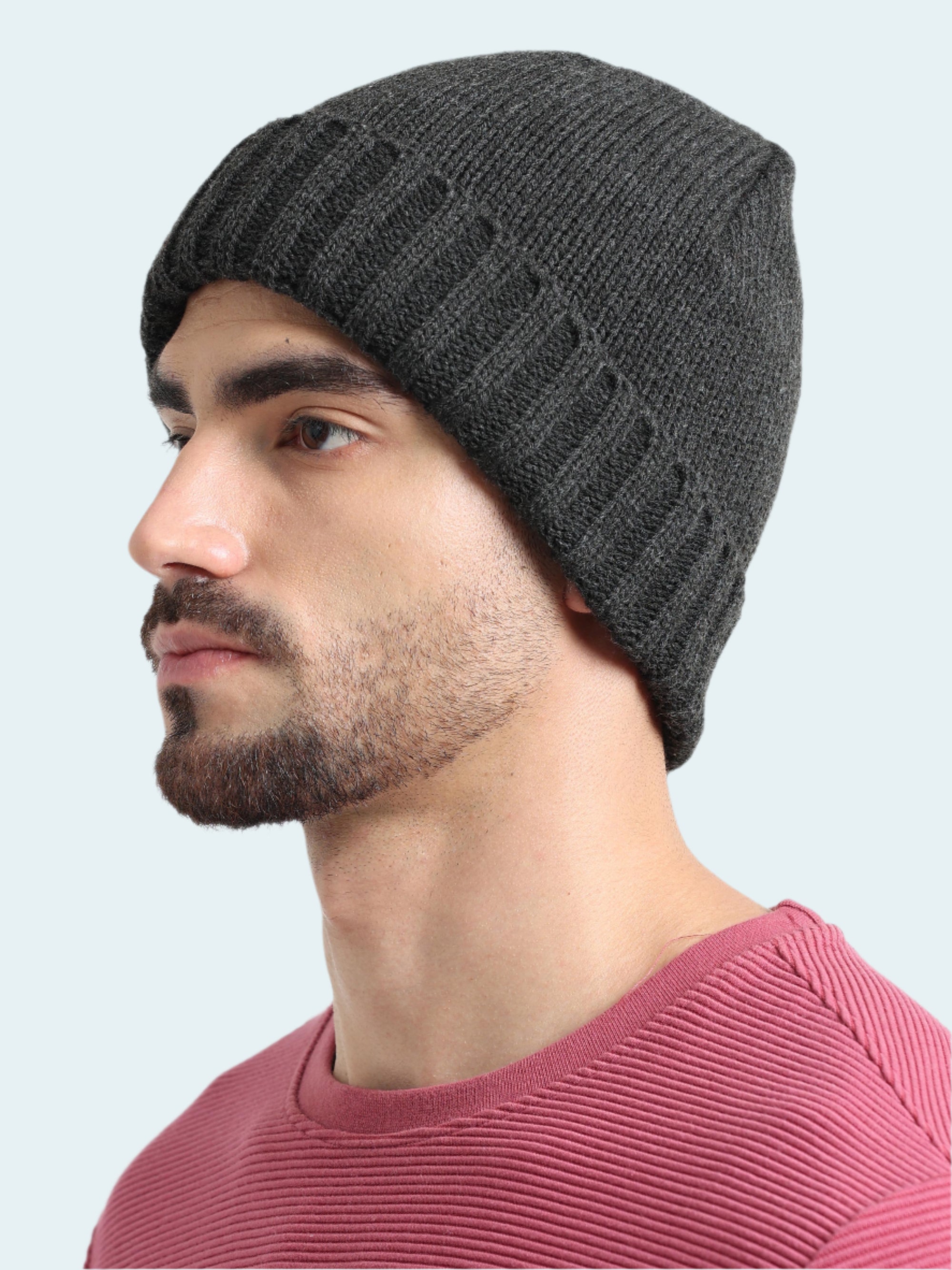 Man wearing a dark gray knit beanie against a white background