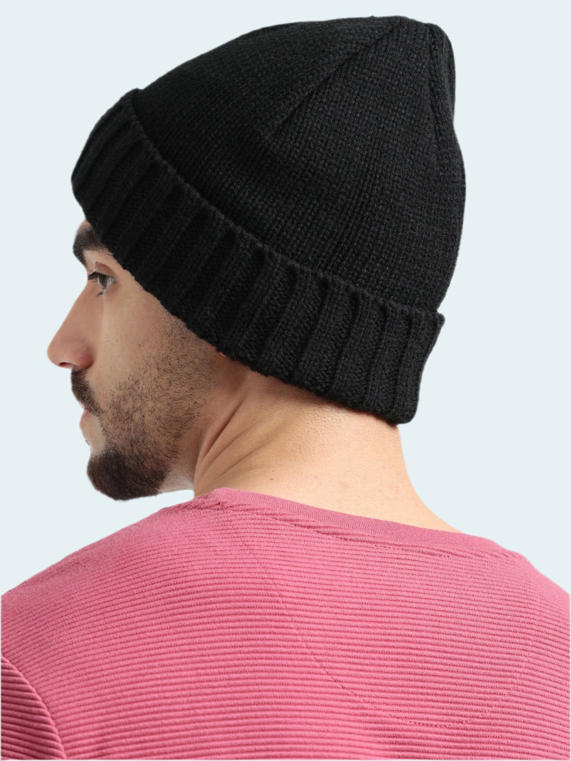 Man wearing a black beanie and pink shirt on a white background