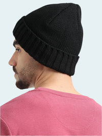 Man wearing a black beanie and pink shirt on a white background