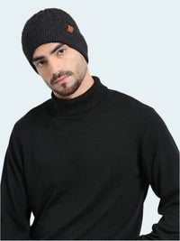 Man wearing a black knit beanie and black turtleneck sweater on a white background