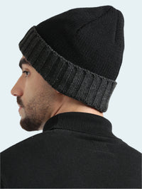 Man wearing a black knit beanie against a white background