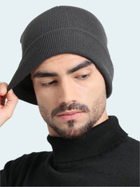 Man wearing a gray knit beanie against a plain background