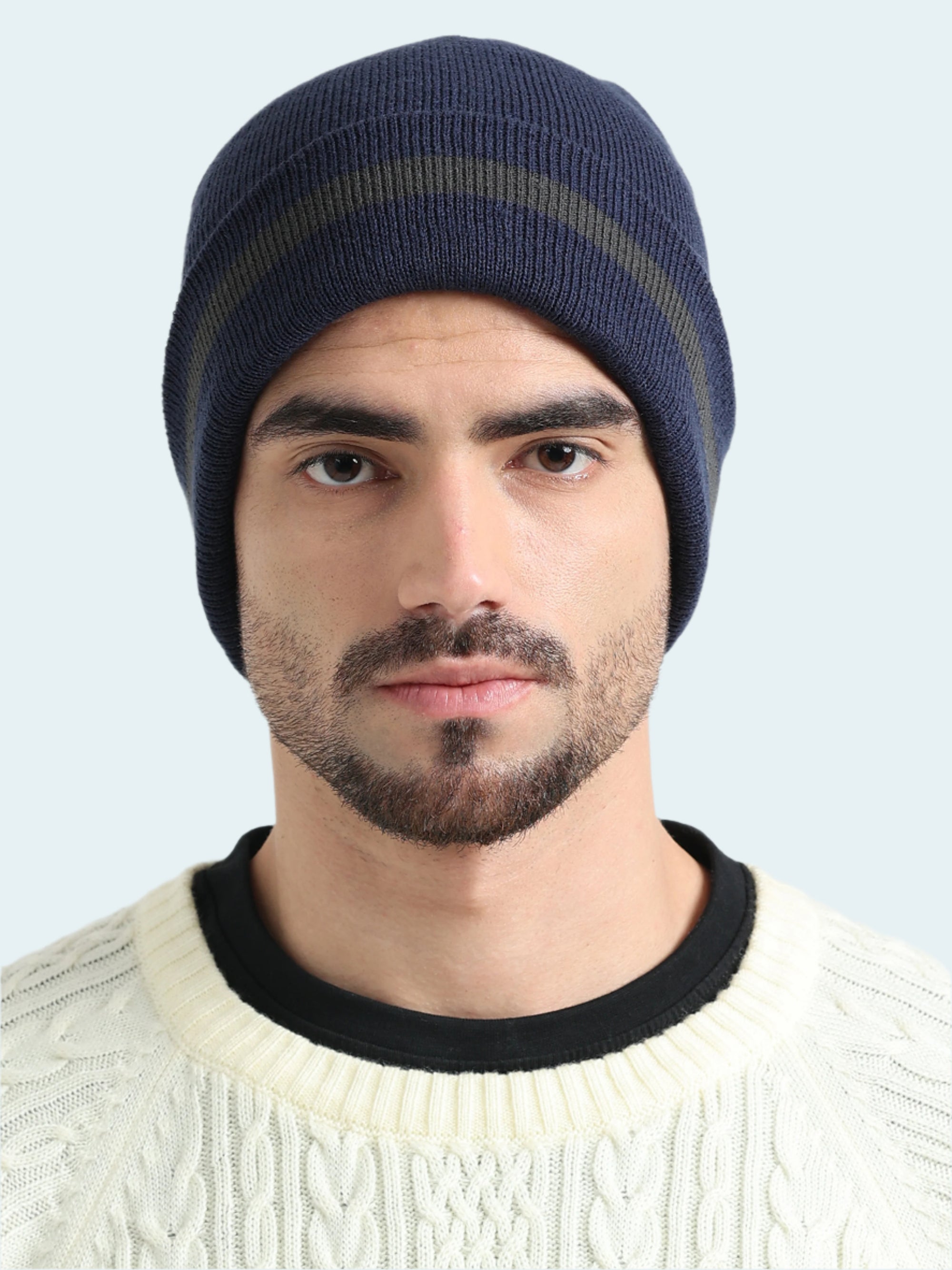 Man wearing a navy blue beanie with a white background