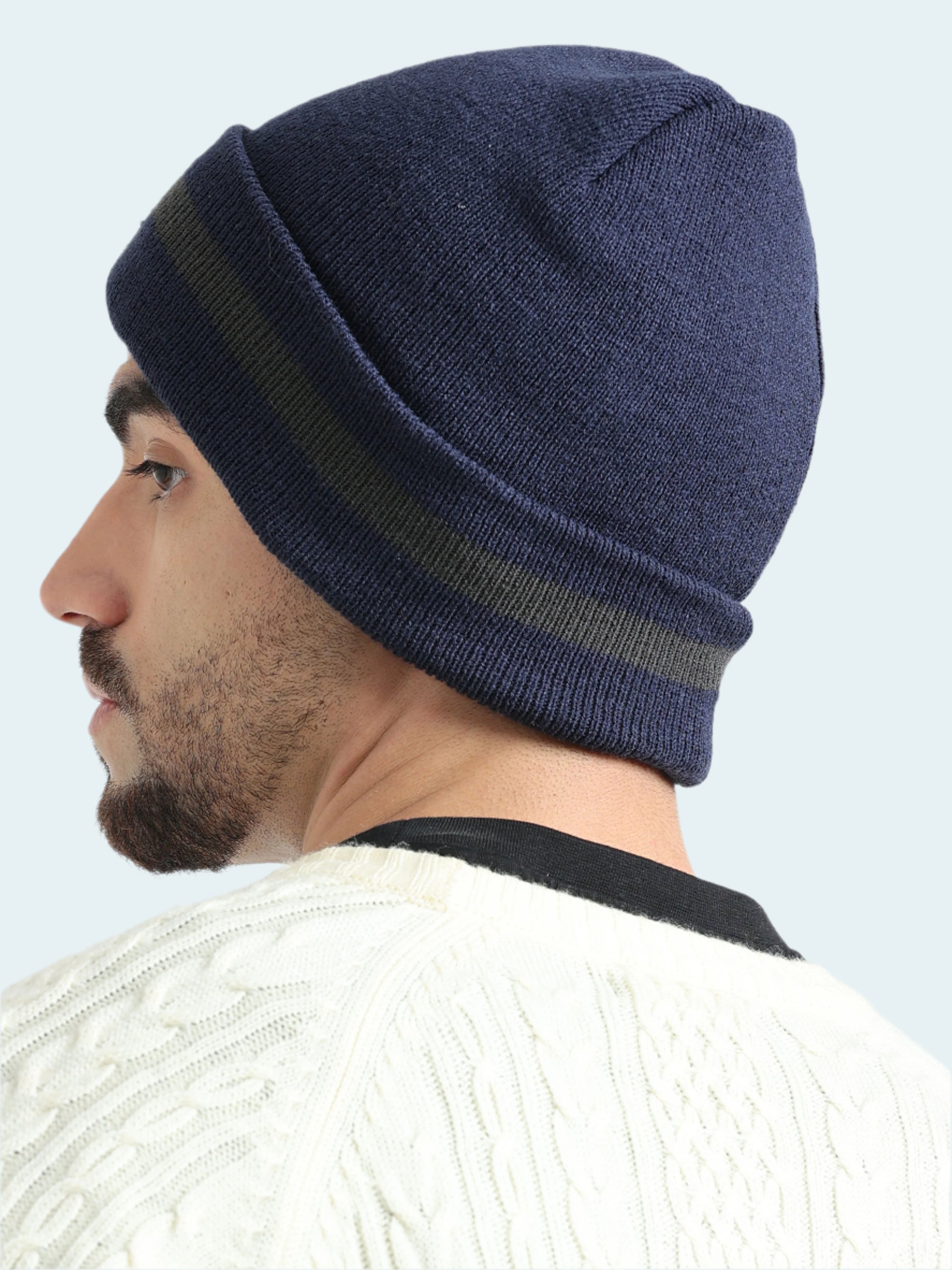 Man wearing a navy blue beanie with a white background