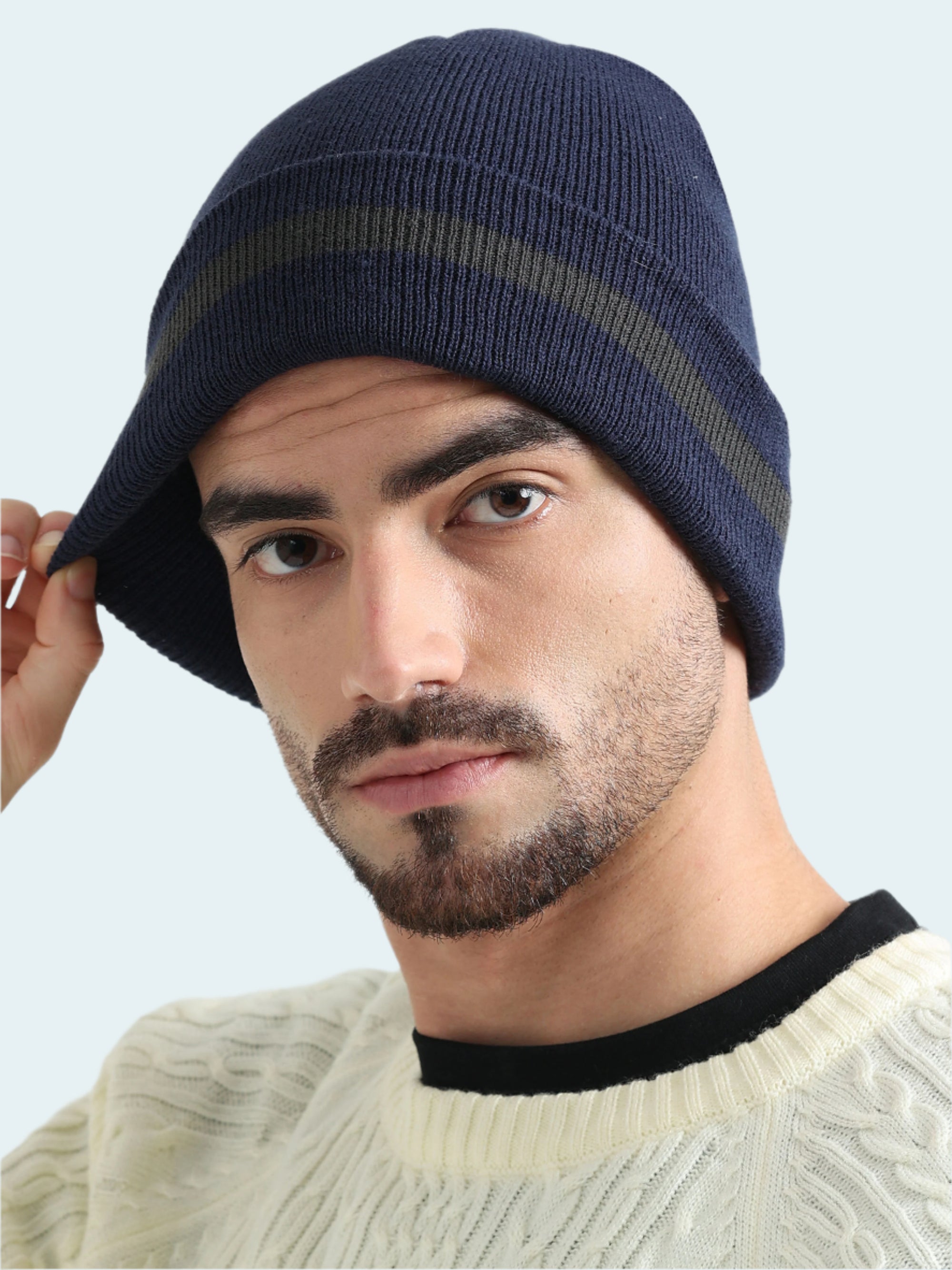 Man wearing a navy blue beanie with a white background