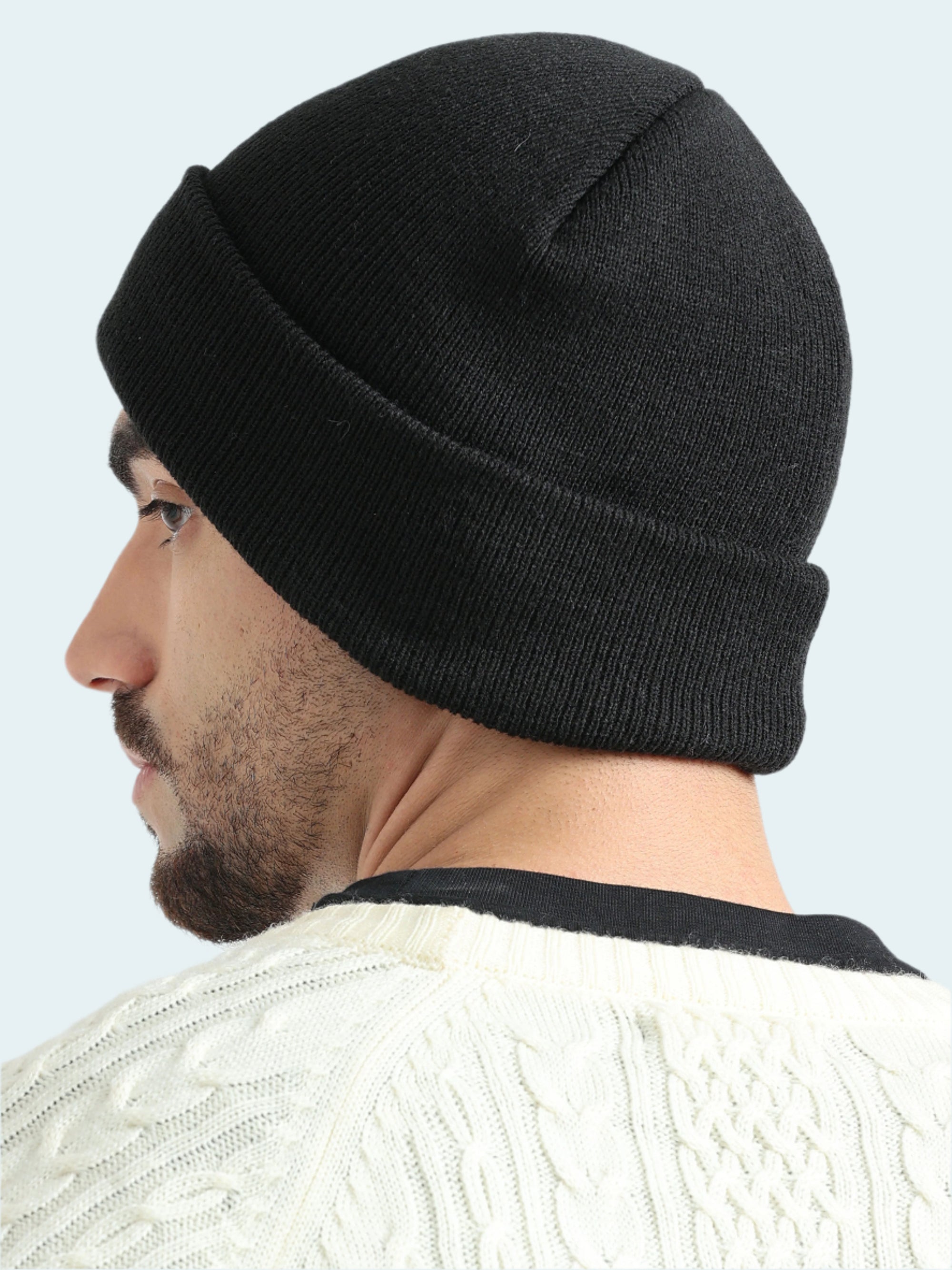 Person wearing a black beanie on a white background