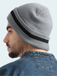 Person wearing a gray knit beanie with a black stripe on a white background