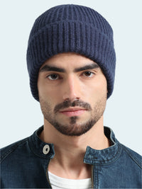 Man wearing a blue knit beanie and denim jacket on a white background