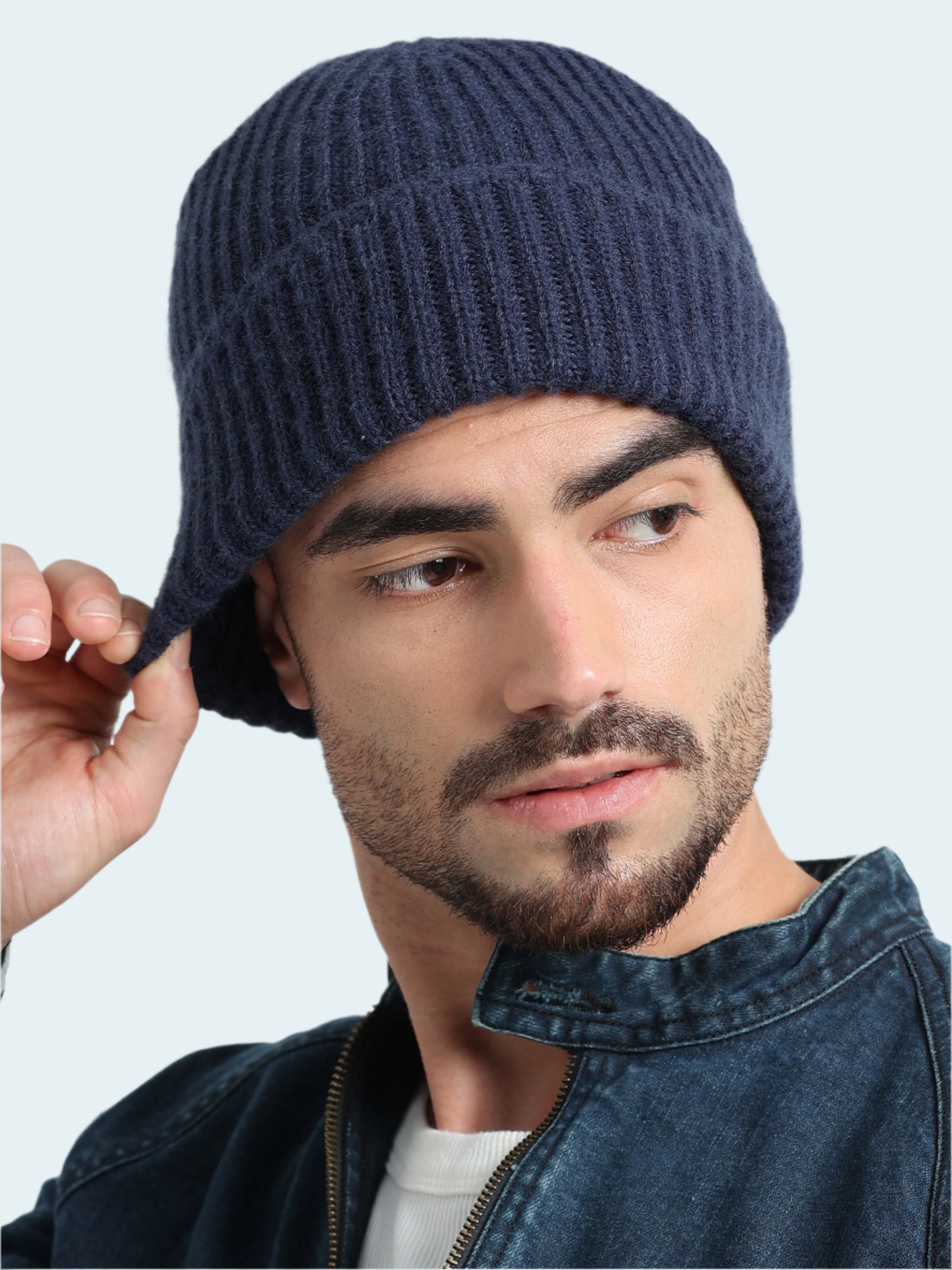 Man wearing a blue knit beanie against a light gray background
