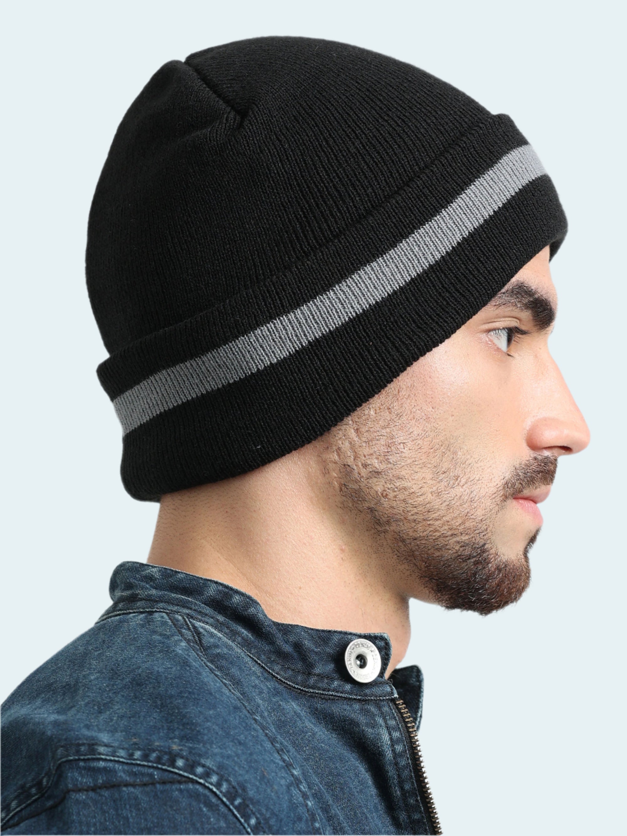 Man wearing a black beanie with a gray stripe on a white background