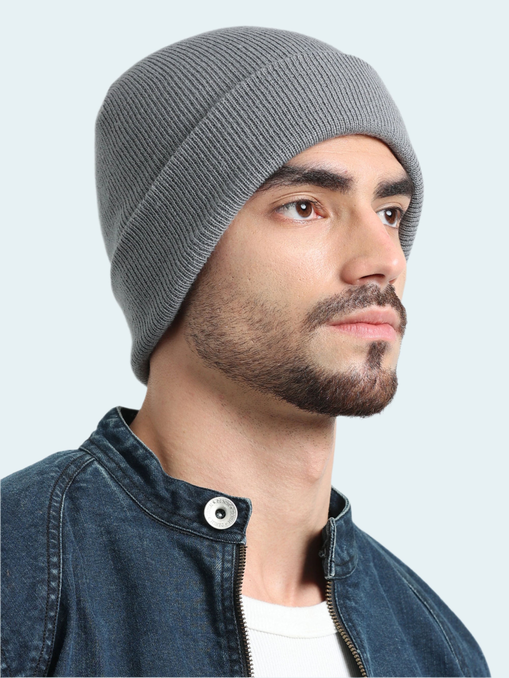 Man wearing a gray knit beanie against a light gray background