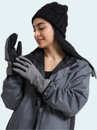 Woman wearing a gray coat, black beanie, and gloves on a white background