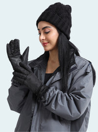 Woman wearing a black knit hat, gray jacket, and black gloves on a white background