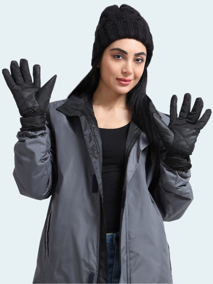 Woman wearing a gray coat, black beanie, and gloves on a white background