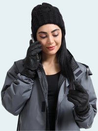 Woman wearing a gray jacket, black beanie, and gloves on a white background