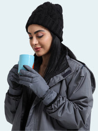 Woman in winter clothing holding a blue mug against a white background