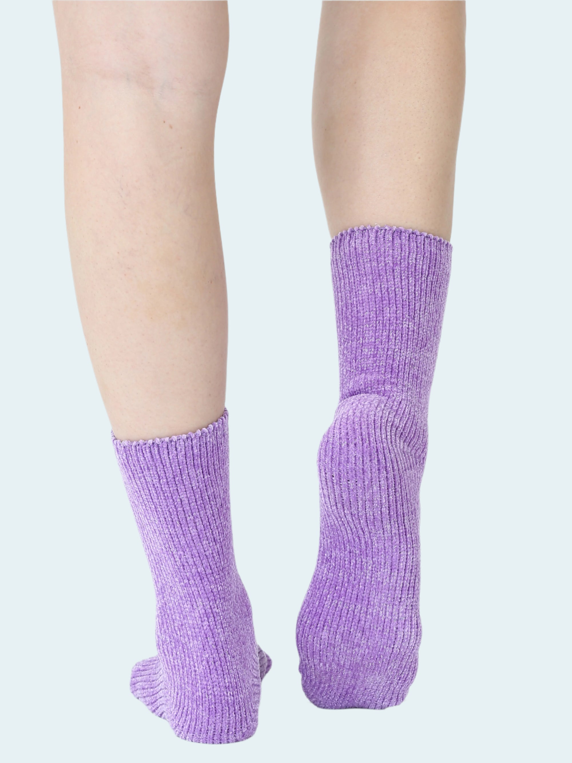Purple socks worn by a person on a white background