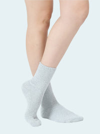Light gray socks worn by a person on a white background