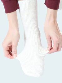 Person wearing a white sock on a white background