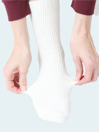 Person wearing a white sock on a white background