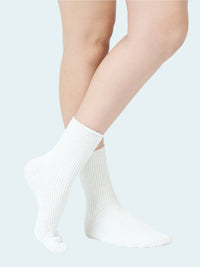 White socks worn by a person on a light gray background