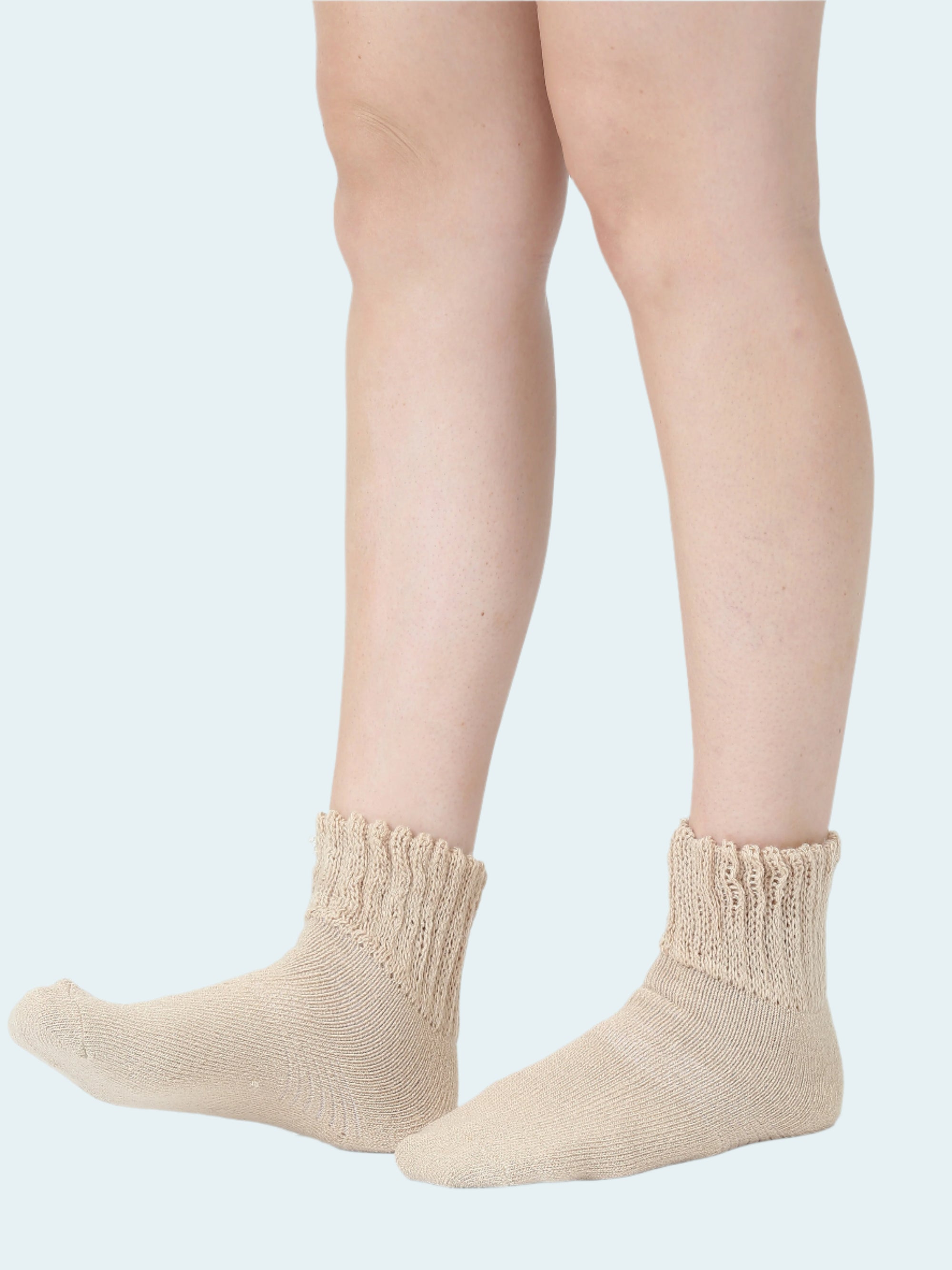 Beige socks worn by a person on a white background