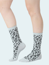 Gray socks with a black leopard print worn by a person on a white background