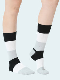 White socks with black accents worn by a person on a white background