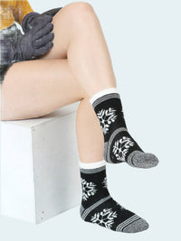 Person wearing black and white patterned socks with a white background