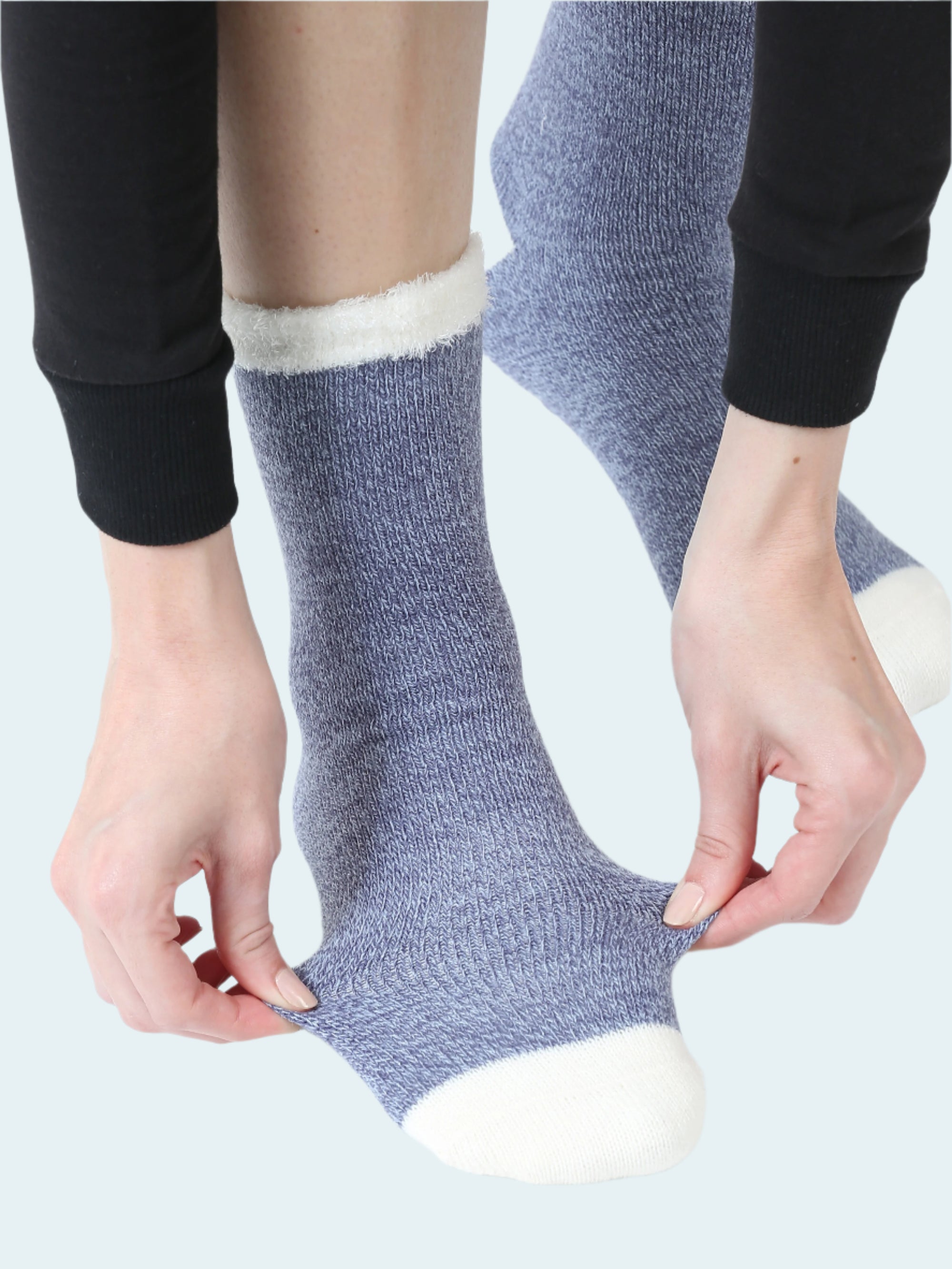 Person wearing blue socks with white toes and cuffs on a white background