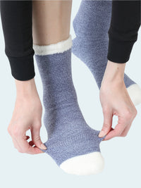 Person wearing blue socks with white toes and cuffs on a white background