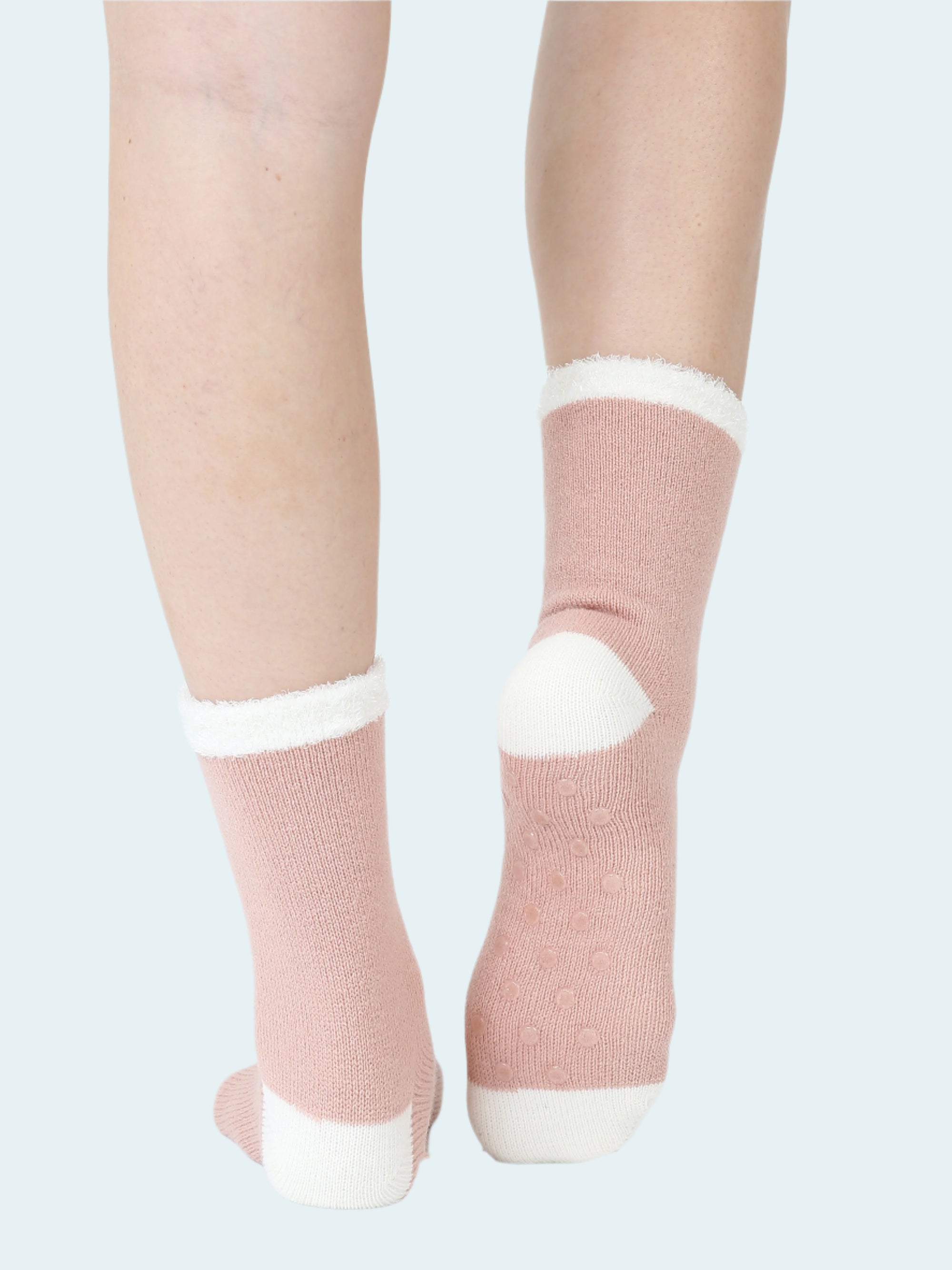 Pink socks with white accents worn by a person on a white background