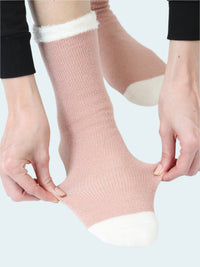 Person wearing pink socks with white accents on a white background