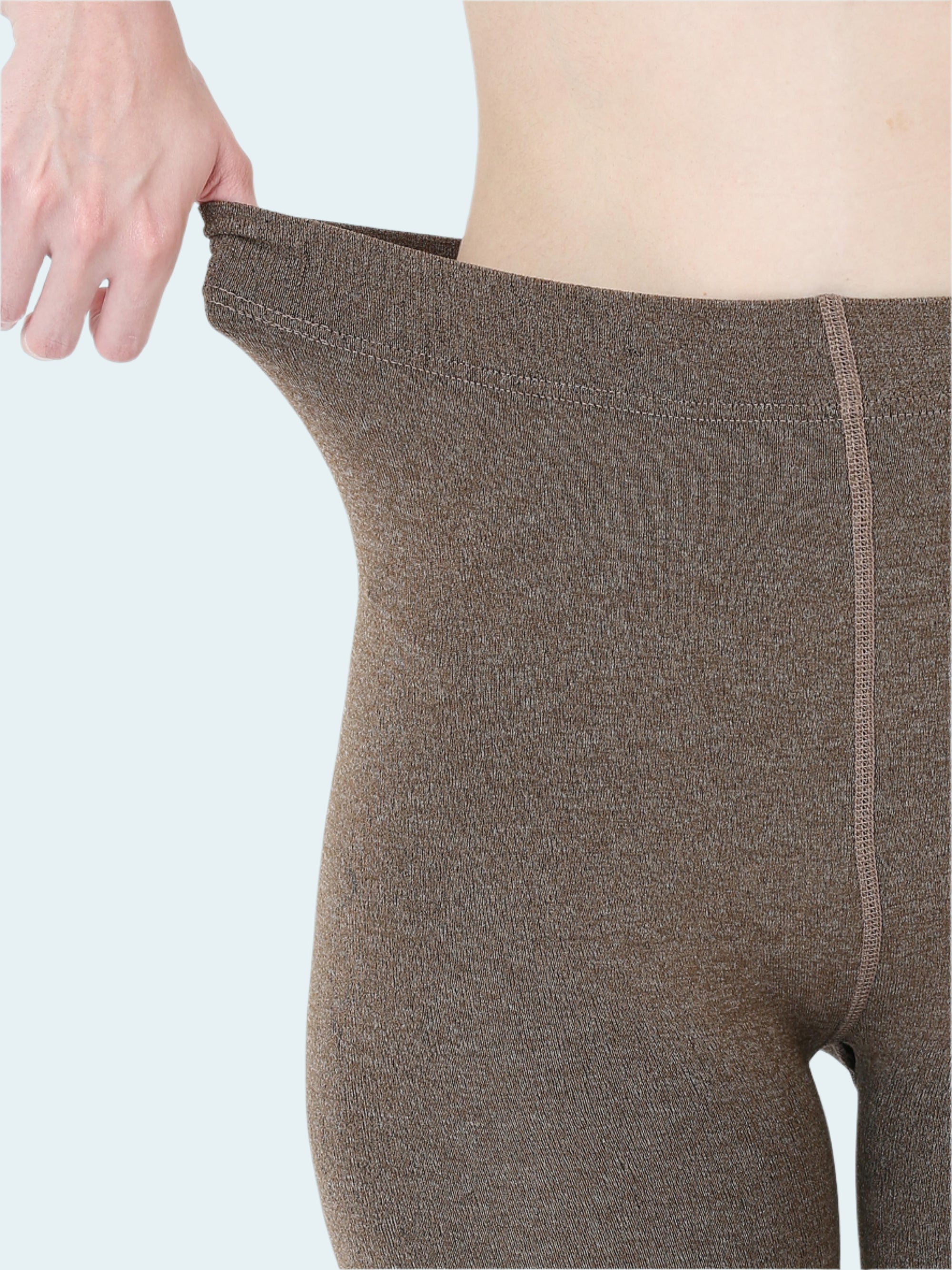 Brown leggings being worn on a white background