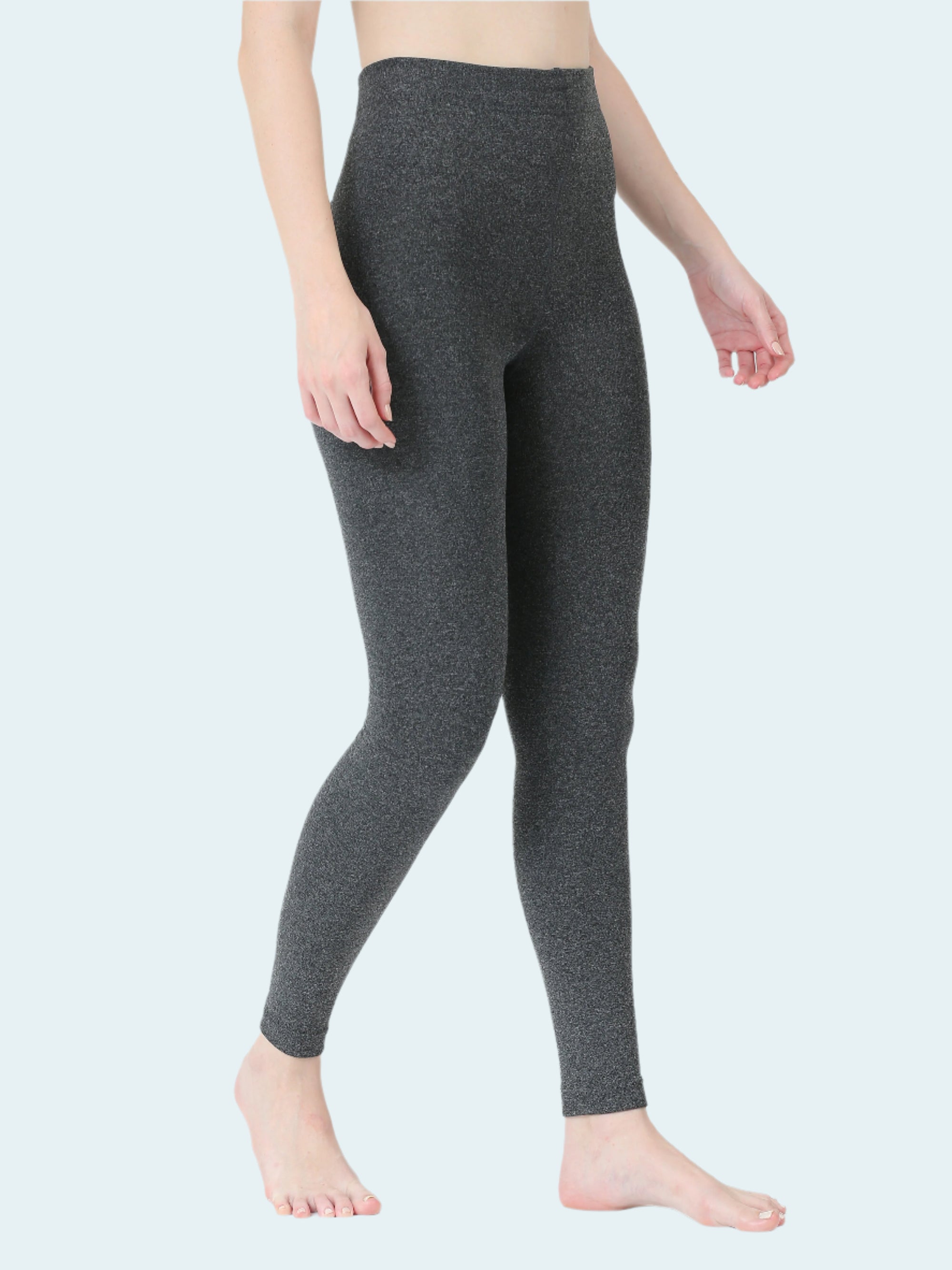 Person wearing dark gray leggings on a white background