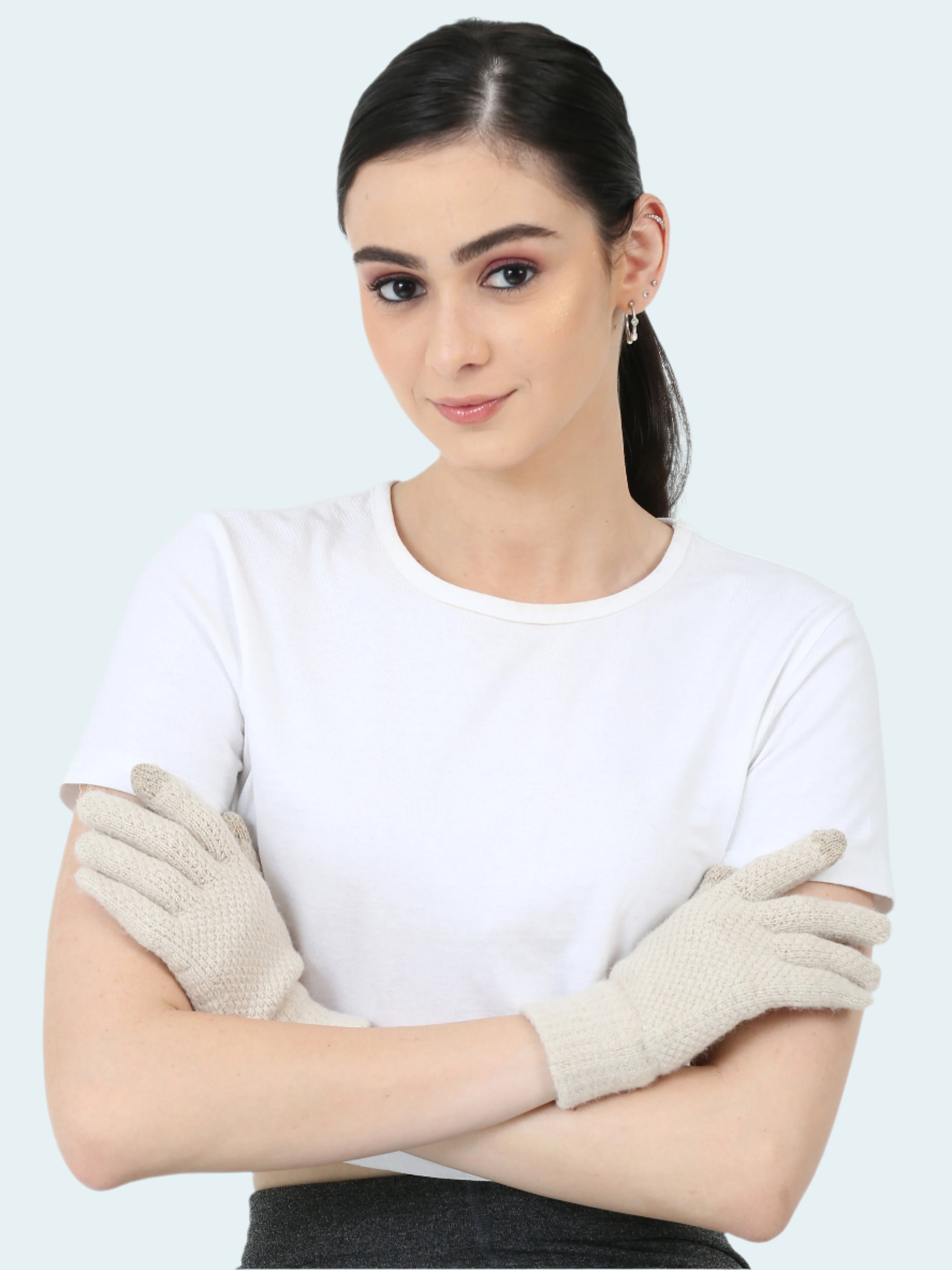 A woman wearing a white shirt and beige knit gloves with touch tip.