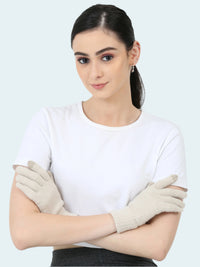 A woman wearing a white shirt and beige knit gloves with touch tip.