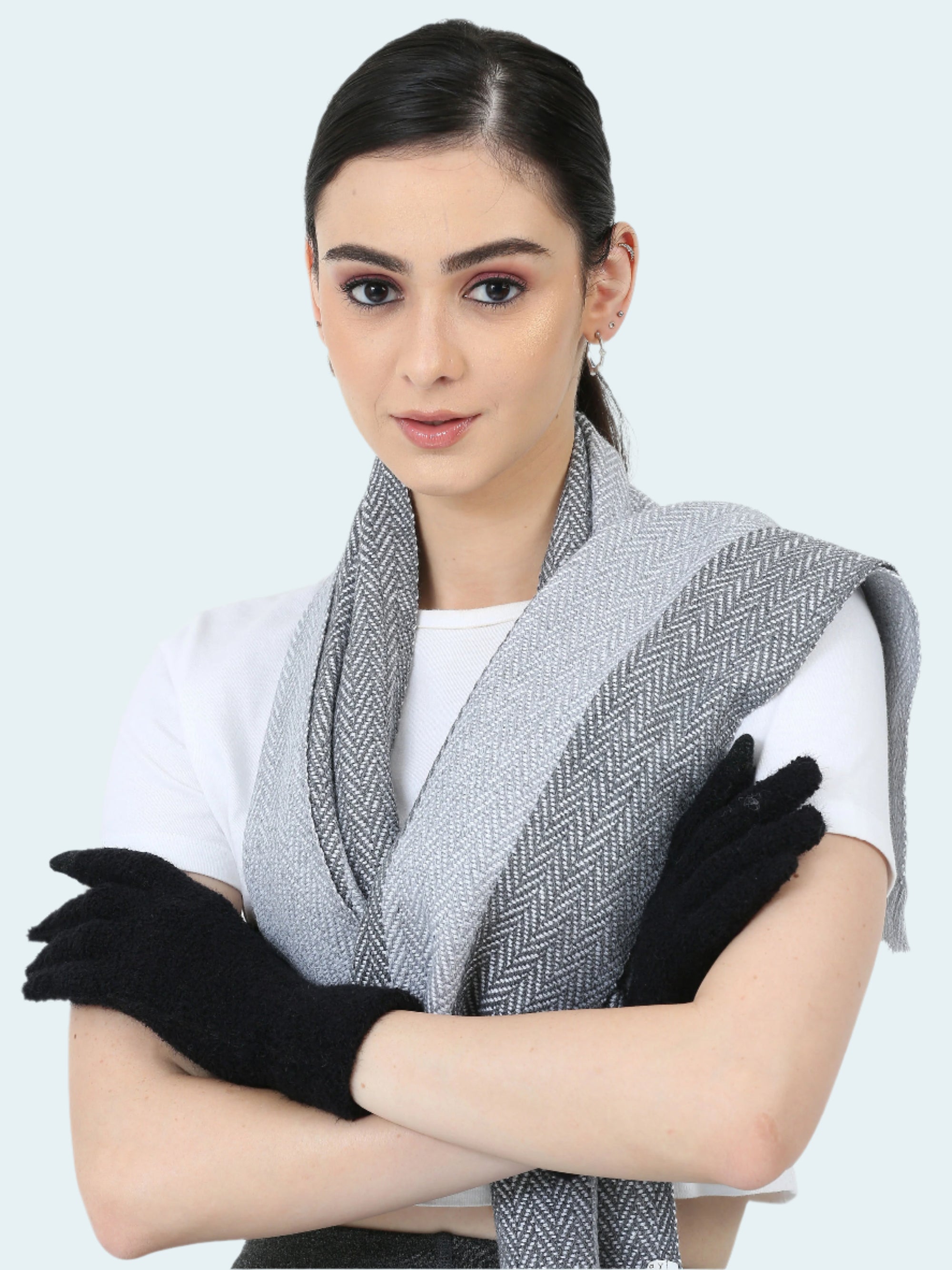 Woman wearing a gray patterned scarf and black gloves on a white background