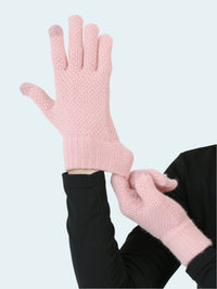 Pink knitted gloves being worn on a plain background