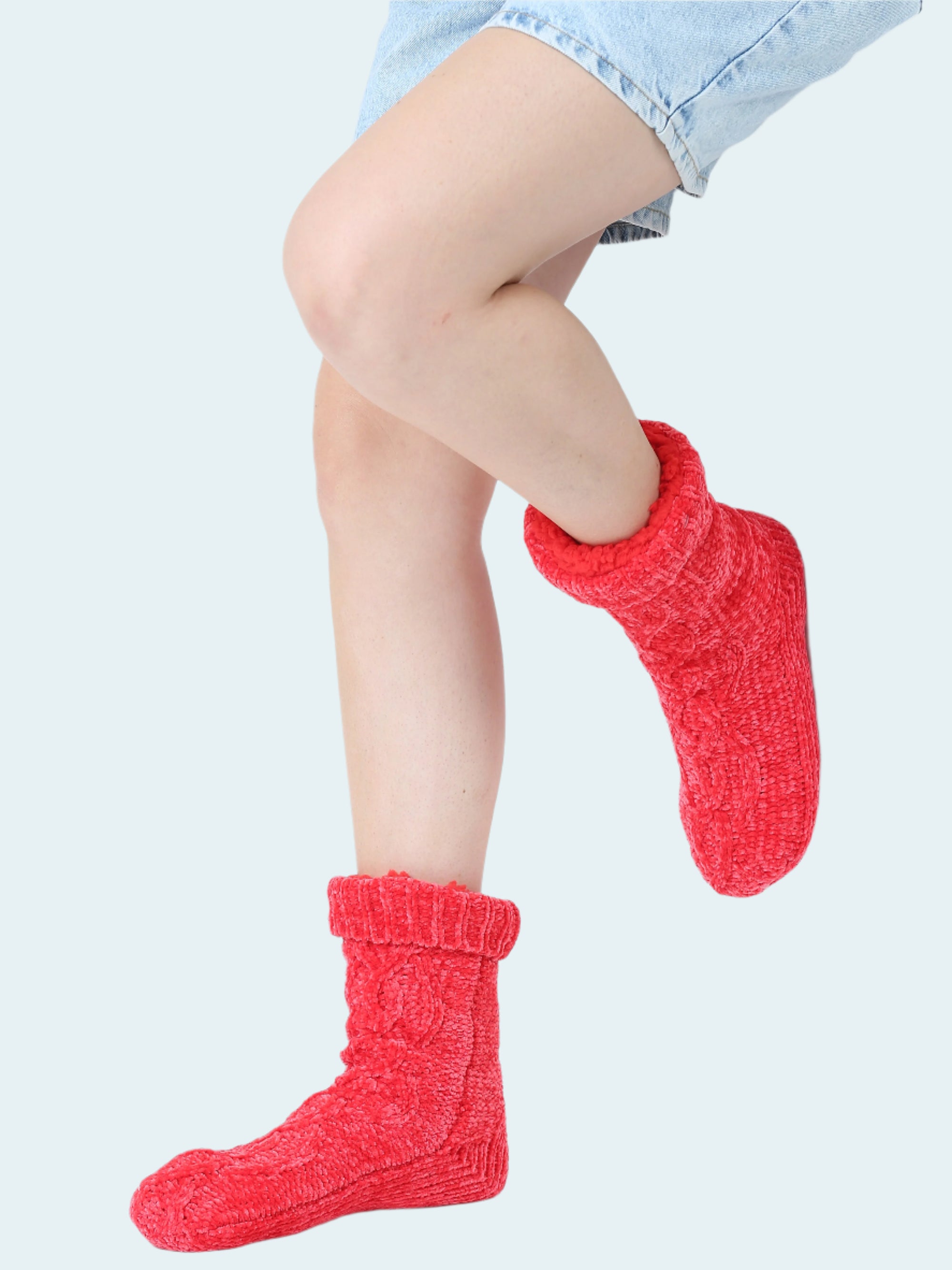 Red knitted chenille socks worn by a person on a white background