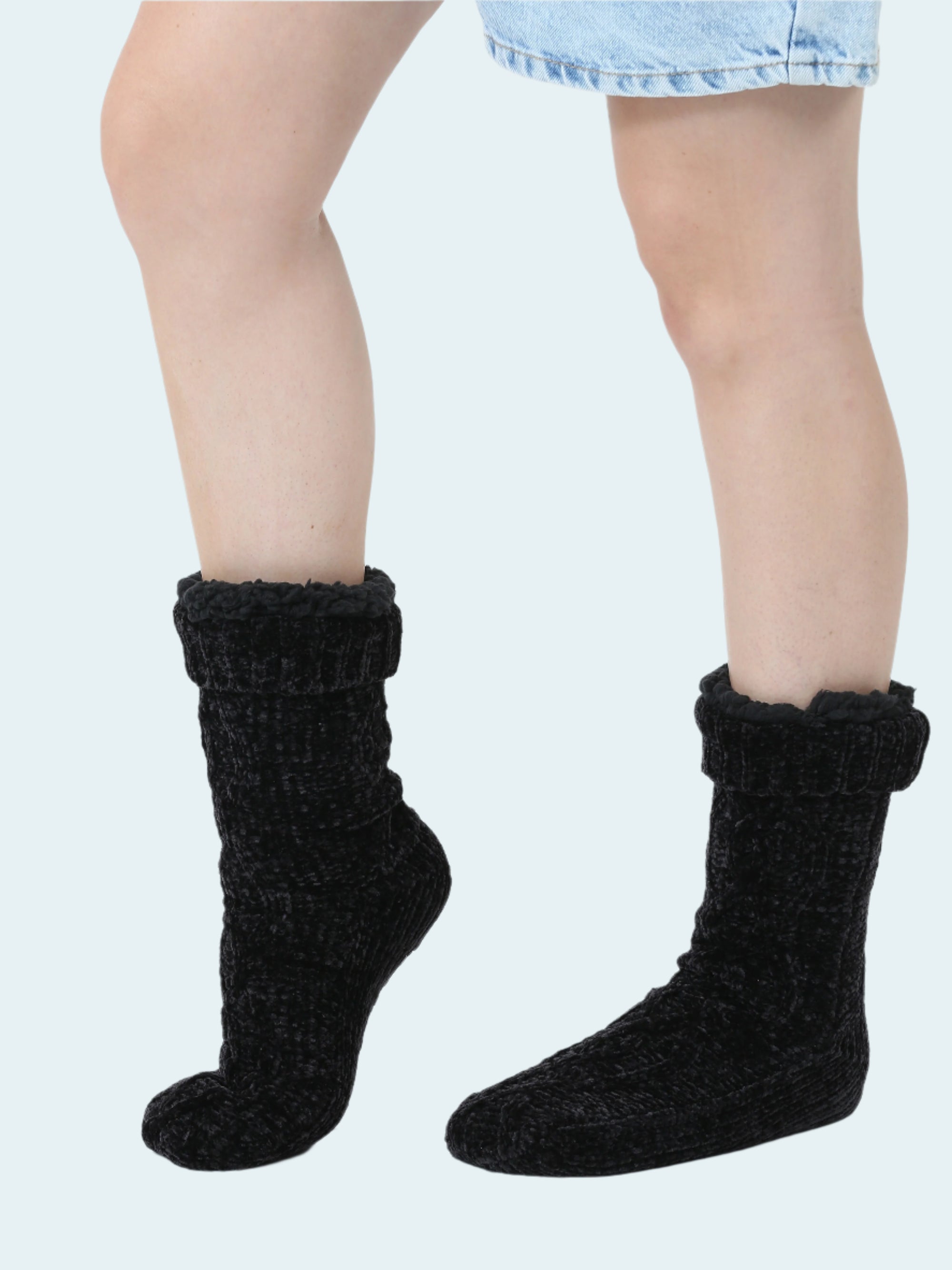 Black knitted chennile socks worn by a person on a white background