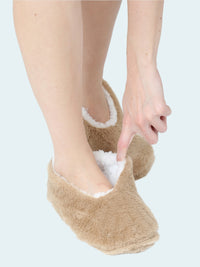Beige slipper socks worn by a person on a white background