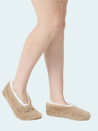 Beige slipper socks worn by a person on a white background