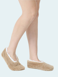Beige slipper socks worn by a person on a white background