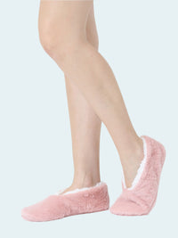 Pink fuzzy slipper socks worn by a person on a white background