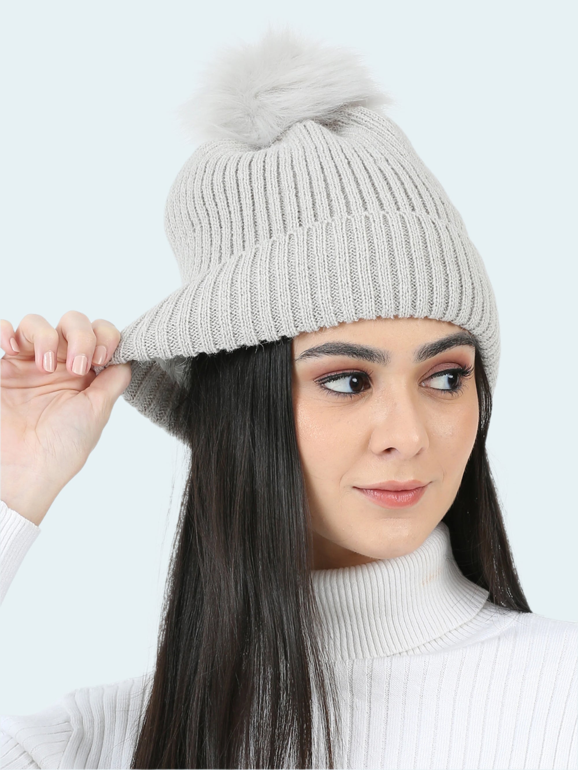 Woman wearing a gray knit beanie on a white background
