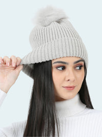 Woman wearing a gray knit beanie on a white background