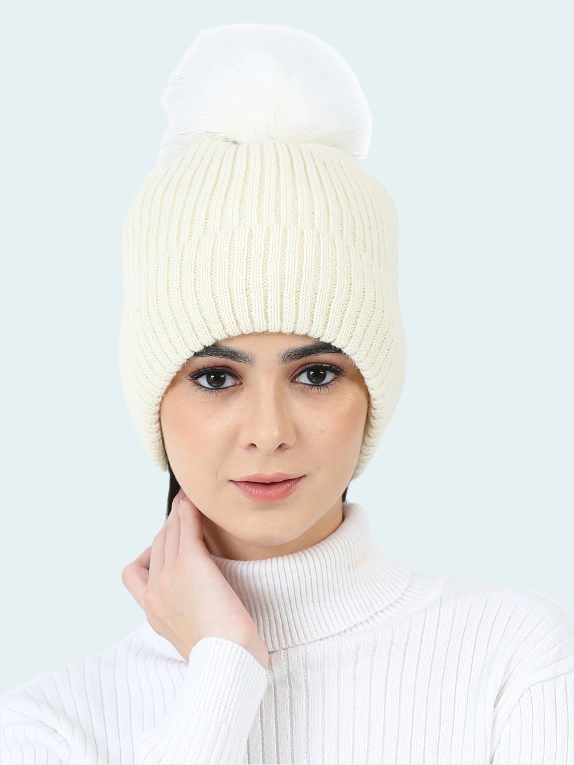 Woman wearing a white knit beanie and sweater on a white background
