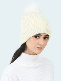 Woman wearing a white knit beanie and turtleneck against a light gray background